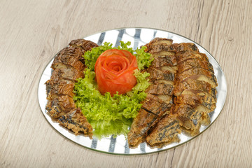 Sliced herring on a plate with herbs.