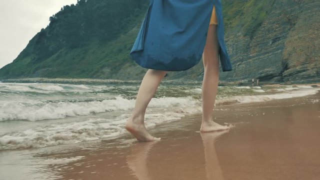 4 k beautifull young girl, mother walking and taking time with her cute little baby, among the Cantabrian coast, in the bay of Atlantic ocean at cloudy morning