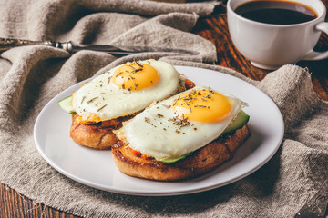 Toasts with vegetables and fried eggs with cup of coffee