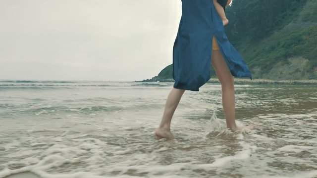 4 k beautifull young girl, mother walking and taking time with her cute little baby, among the Cantabrian coast, in the bay of Atlantic ocean at cloudy morning
