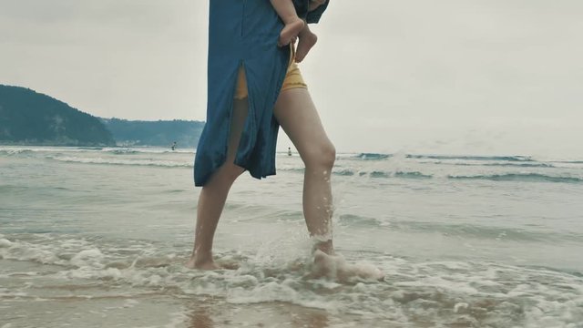 4 k beautifull young girl, mother walking and taking time with her cute little baby, among the Cantabrian coast, in the bay of Atlantic ocean at cloudy morning