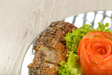 Sliced herring on a plate with herbs.