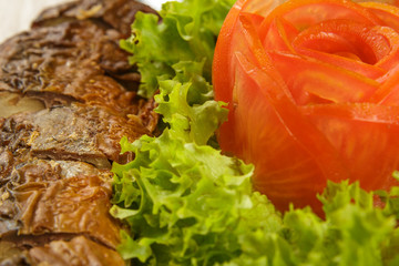 Sliced herring on a plate with herbs.