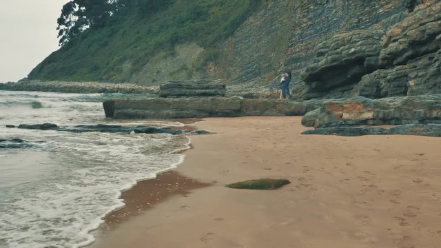 4 k beautifull young girl, mother walking and taking time with her cute little baby, among the Cantabrian coast, in the bay of Atlantic ocean at cloudy morning