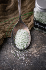 Lemon Lavender Herb Salt in Tarnished Spoon on Black Background with Fresh Sprig of Lavender