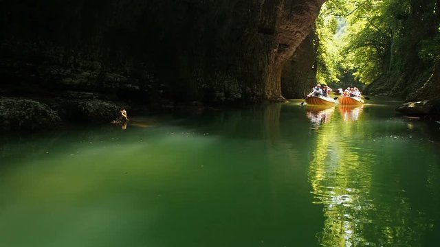 People Rafting In Rubber Rowing Boats in Natural Canyon. Beautiful River Among Cliffs 25 fps