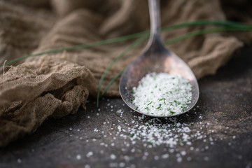 Chive Herb Salt in Tarnished Spoon on Black Background with Fresh Sprigs of Chives