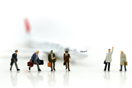 Miniature people : businessman waiting for a taxi in front of the airport,business meeting concept.