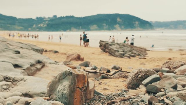 4 k Atlantic coast with rocks of differnt colour, orange sand and waves of ocean water at cloudy day, Cantabrian seaside