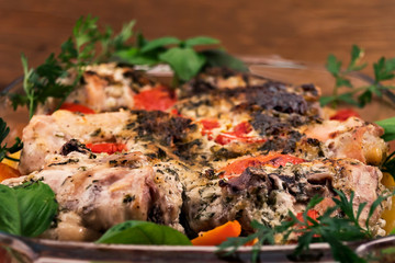 Grilled chicken with tomatoes, potatoes and carrots, decorated with parsley and basil  leaves.