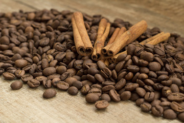 cinnamon sticks and coffee beans on wooden background