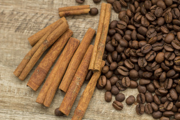 Coffee beans and cinnamon sticks on wooden background
