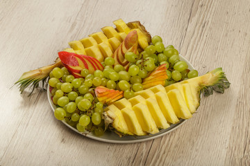 Very nice and artistically sliced fruits on a platter.