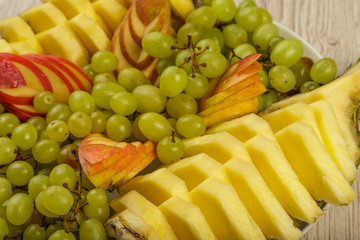 Very nice and artistically sliced fruits on a platter.