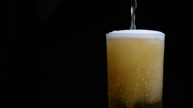 Beer Is Pouring Into Glass With Foam Sliding Down Side Of Beer Glass