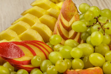 Very nice and artistically sliced fruits on a platter.