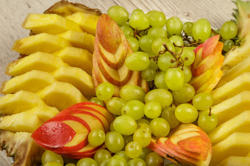 Very nice and artistically sliced fruits on a platter.