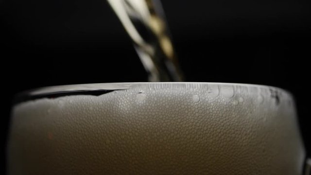 Beer Is Pouring Into Glass With Foam Sliding Down Side Of Beer Glass