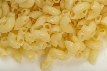 Boiled yellow pasta on a white plate.