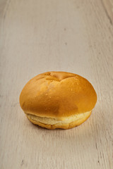 Fresh ruddy bun on a wooden background.