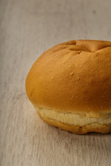 Fresh ruddy bun on a wooden background.