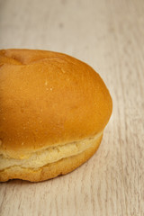 Fresh ruddy bun on a wooden background.