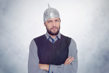 Bearded funny man in a cap of aluminum foil. Concept art phobias