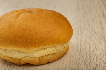 Fresh ruddy bun on a wooden background.