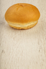 Fresh ruddy bun on a wooden background.