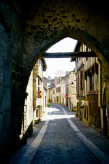 Streets and buildings of medieval french old town viewed through the fortress gates