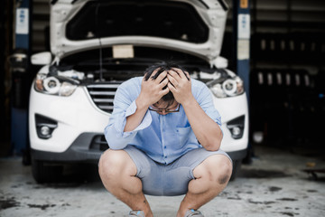 Young Asian man with stress, headaches, with the cost of repairing the car.