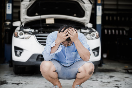 Young Asian Man With Stress, Headaches, With The Cost Of Repairing The Car.