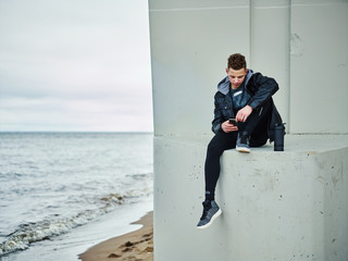 Young sportsman relaxing with smartphone