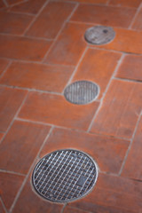 Fototapeta na wymiar Small round manhole cover on the footpath