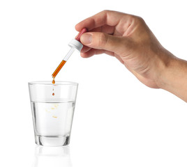 Hand pouring a cosmetic product into a bottle. Isolated