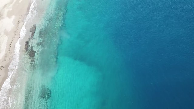 Aerial drone footage of desert beach and blue sea 