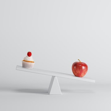 Green Apple Tipping Seesaw With Cup Cake On Opposite End On White Background. Food Idea Minimal.