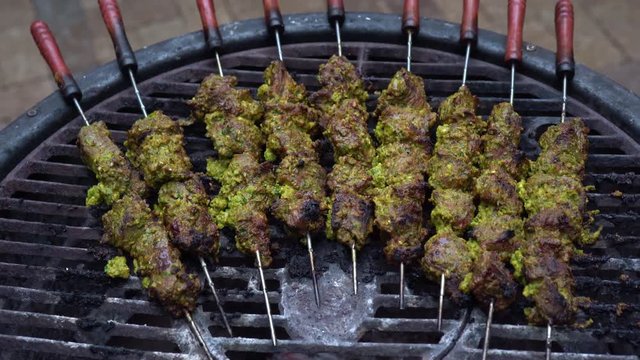 Closeup of meat shish kabobs with a marinade on a smoking grill.