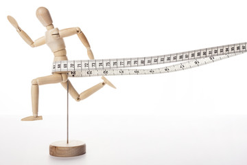 wood Mannequin, human run with tape ruler isolated white.