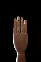 wood Mannequin, hand four on the black background. 