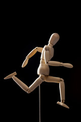 wood Mannequin, human run on the black background. 