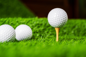 Golf ball with green grass background, on tee closeup.