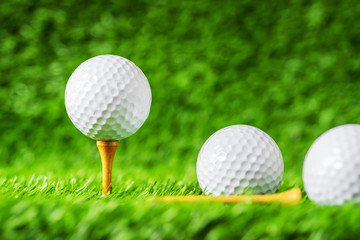 Golf ball with green grass background, on tee closeup.