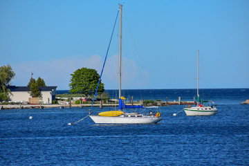 Fototapeta na wymiar Two sailboats anchored off the coast of Michigan on the Great Lakes