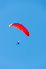 Hang glider soars through a pristine blue sky