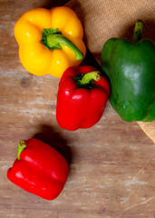 Bell peppers on wooden table. A small spicy and healthy fruit in different colors.