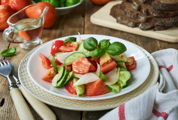 Fresh vegetable salad with ripe tomatoes and cucumbers on a plate