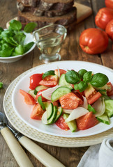 Fresh vegetable salad with ripe tomatoes and cucumbers on a plate