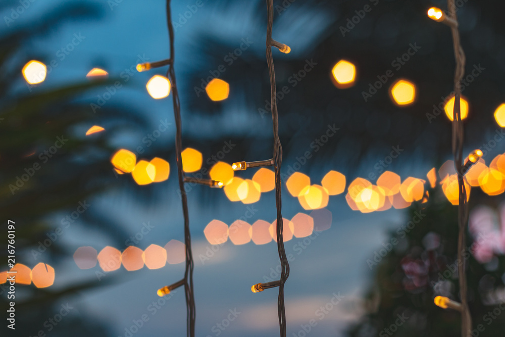 Wall mural blurred light bokeh with coconut palm tree background on sunset