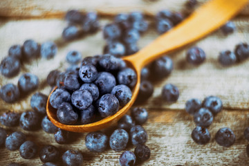 blueberry with wooden spoon on wooden table